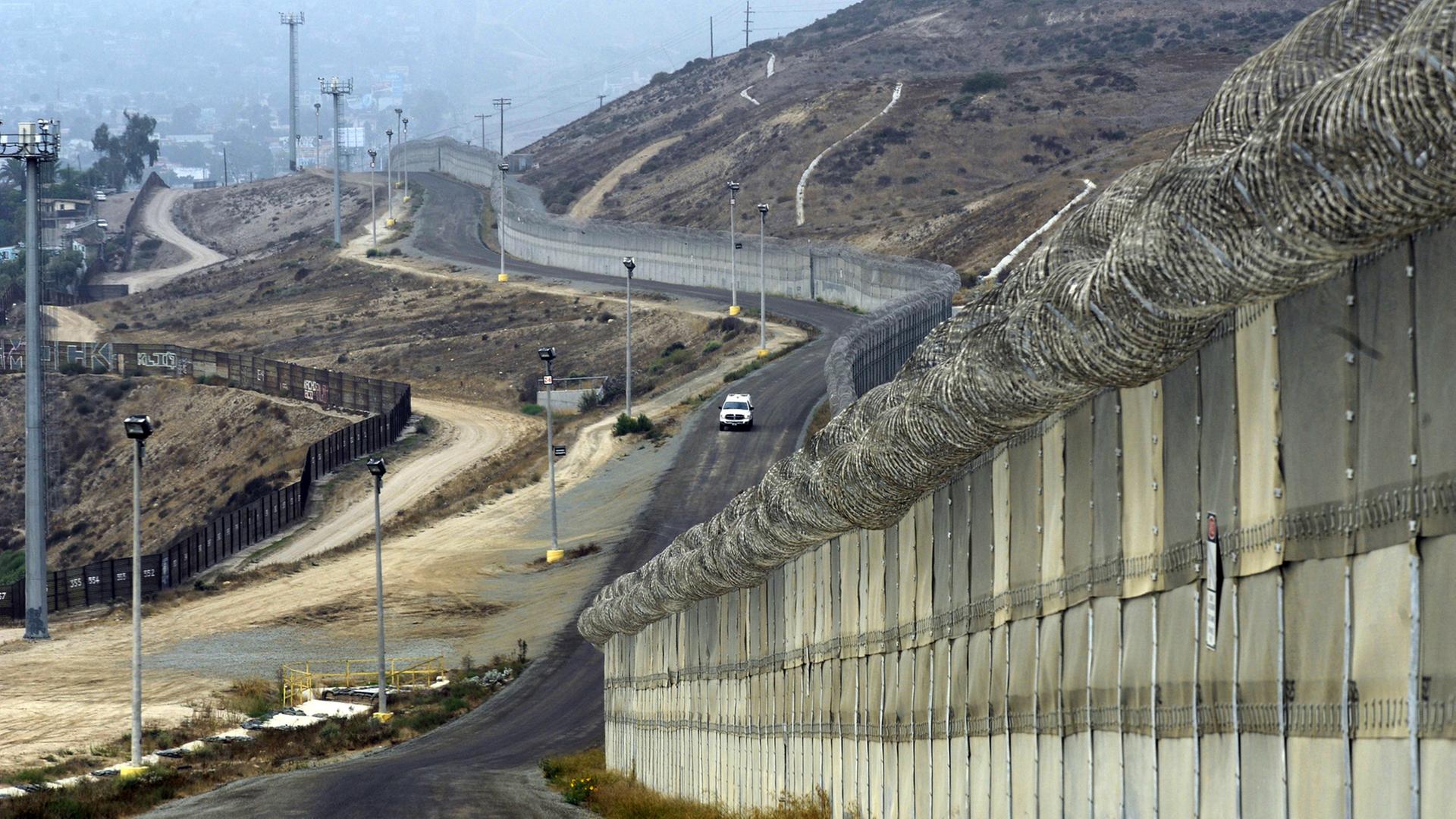 US-Grenzfahnder fahren in einem Auto an Mauern und Befestigungen an der Grenze zu Mexiko entlang, bei Otay Mesa, Kalifornien, USA, am 14. Oktober 2010
