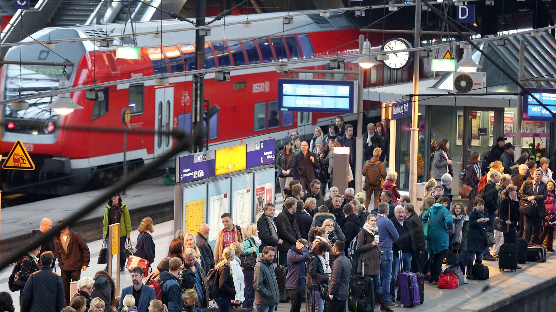 Reisende warten am 15.10.2014 im Hauptbahnhof in Hamburg auf einen Zug, der ursprünglich nach München fahren sollte.