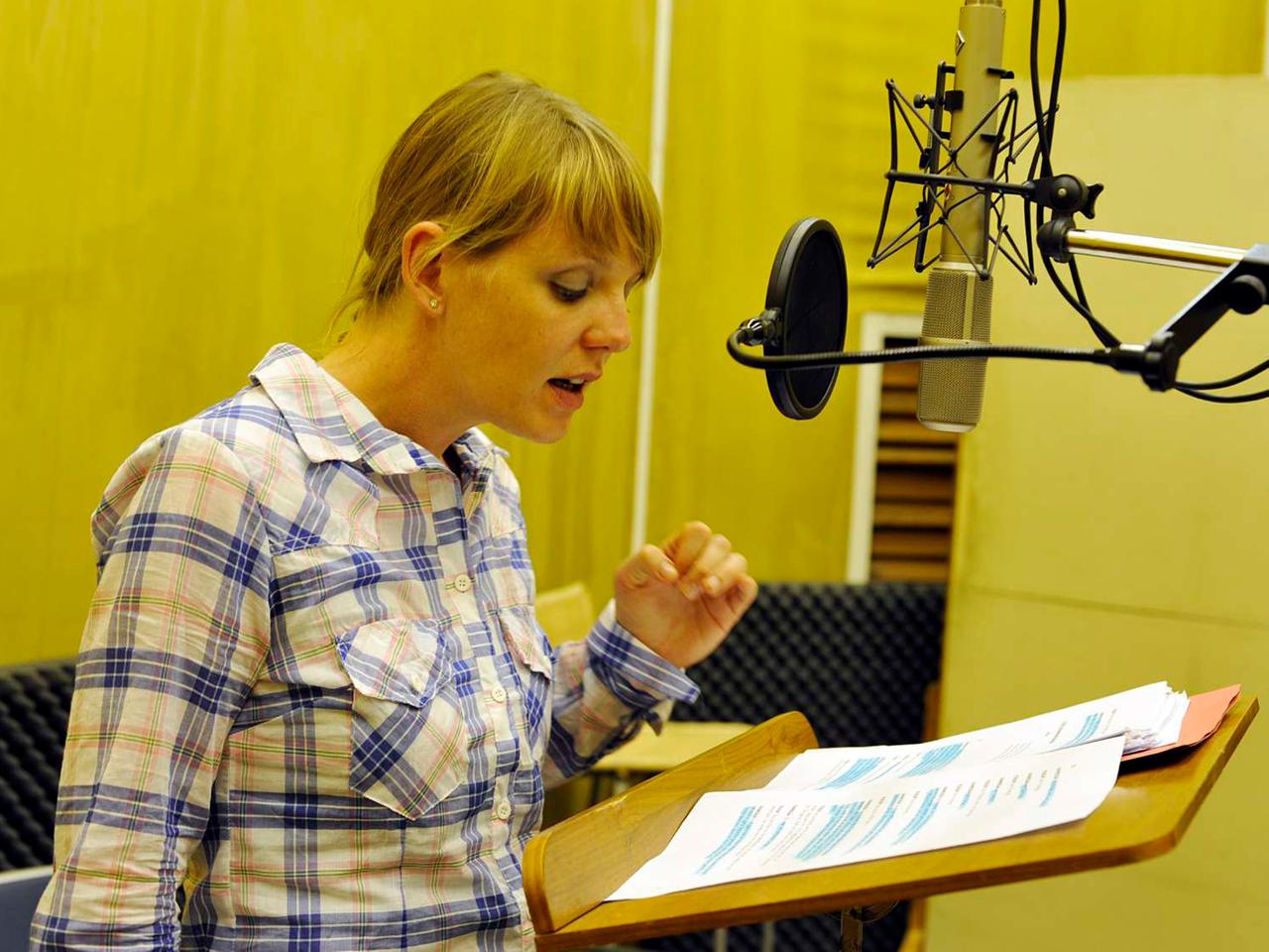 Die Schauspielerin Katrin Wichmann im Studio am Mikrofon.