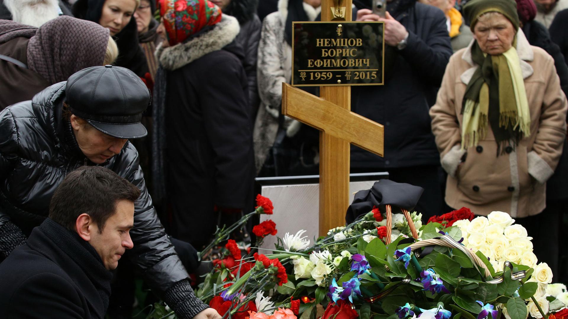 Trauernde, darunter die Oppositionelle Ilya Yashin (l), legen Blumen auf das Grab von Kreml-Kritiker Boris Nemzow auf dem Trojekurowo-Friedhof in Moskau.