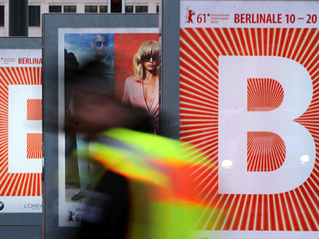 Ein Passant geht an Plakaten der diesjährigen Berlinale am Potsdamer Platz in Berlin vorbei.