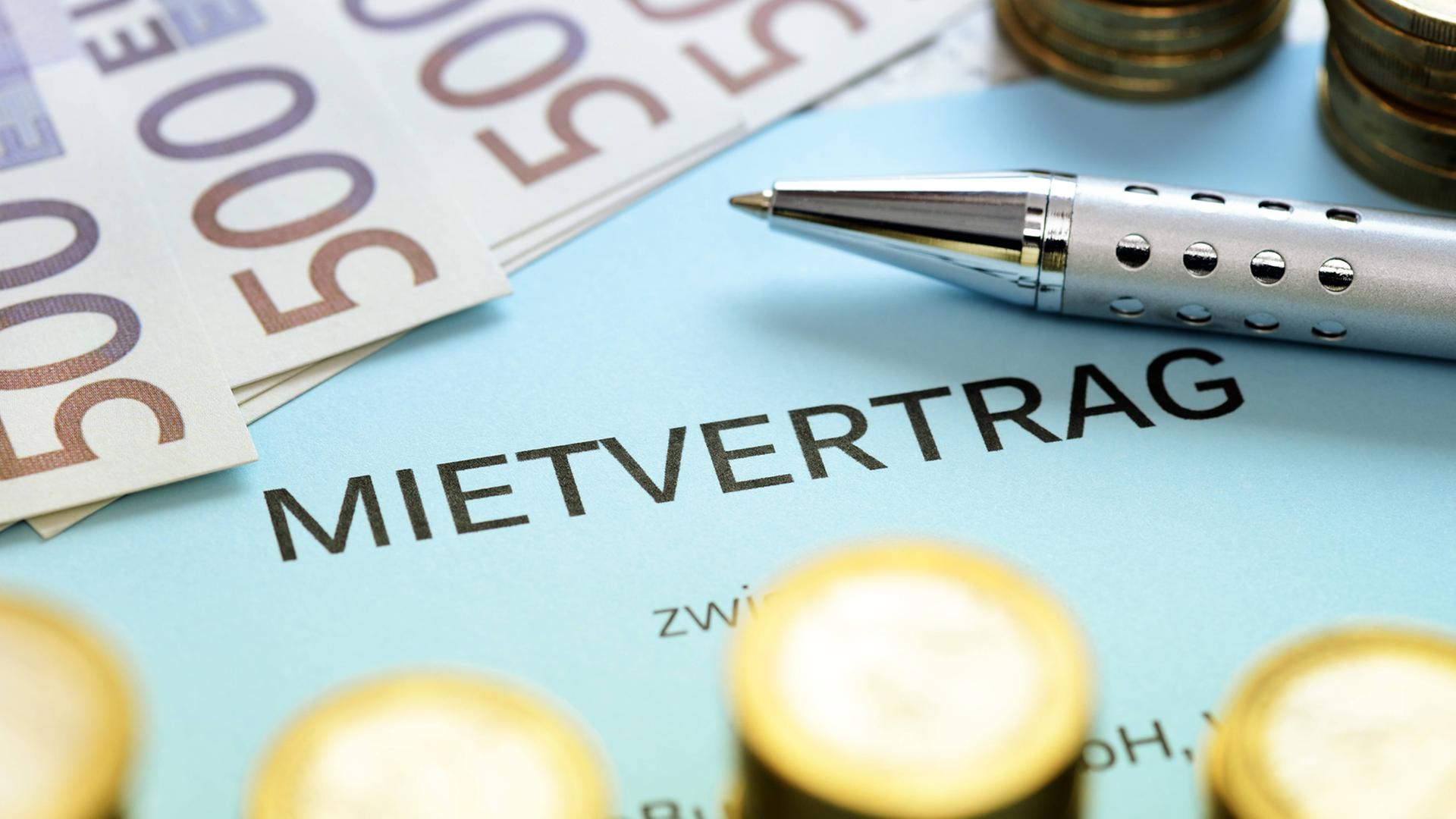 Mehrere Euromünzen und 500-Euro-Scheine liegen auf einem Mietvertrag. Mehrere Euromünzen und 500-Euro-Scheine liegen auf einem Mietvertrag.