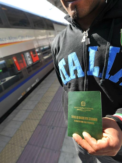 Ein illegaler Flüchtling zeigt am Bahnhof in der italienischen Grenzstadt Ventimiglia seine befristete Aufenthaltserlaubnis.