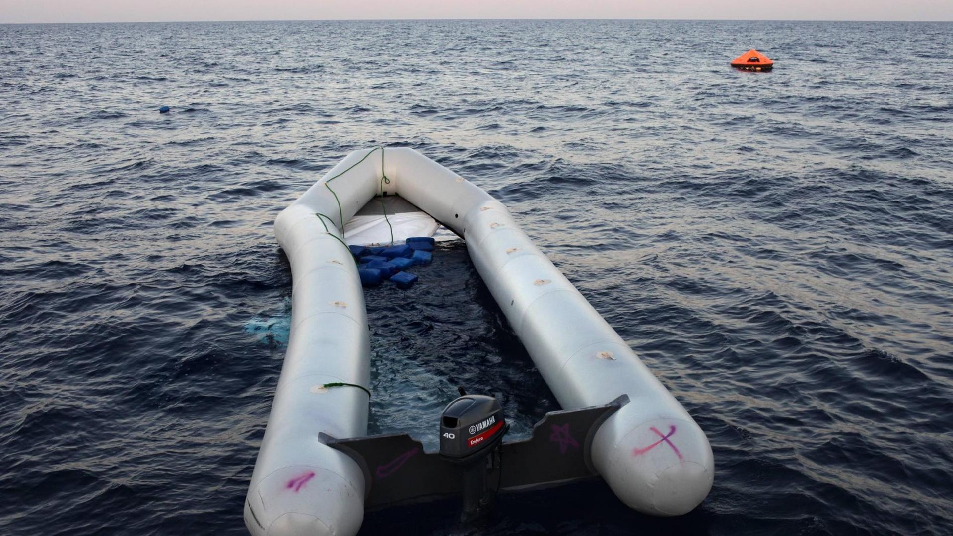 Seenotrettung von Bootsflüchtlingen vor der libyschen Küste Zivile Seenotrettung von Bootsflüchtlingen im Mittelmeer vor Libyen - an Bord des Seenotkreuzers Minden der Organisation LIFEBOAT: Havariertes Flüchtlingsboot . Sein Boden ist ausgebrochen, viele Afrikaner trieben im Wasser, mindestens 2 Menschen sind ertrunken. Im Hintergrund zu sehen: Von der Minden ausgebrachte Rettungsinsel. Mittelmeer, vor libyscher Küste, Internationale Gewässer, 20.10.2016.