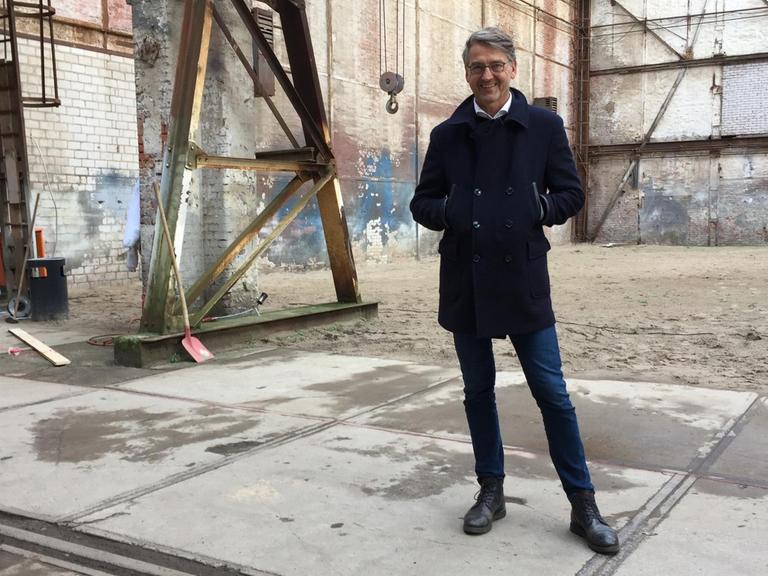 Thilo Gollan steht in einer alten Fabrikhalle auf dem Gelände der Kulturwerft.