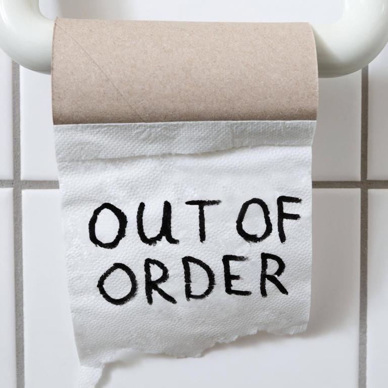 eine fast leere Toilettenpapierrolle auf derem letzten Blatt "out of order" steht