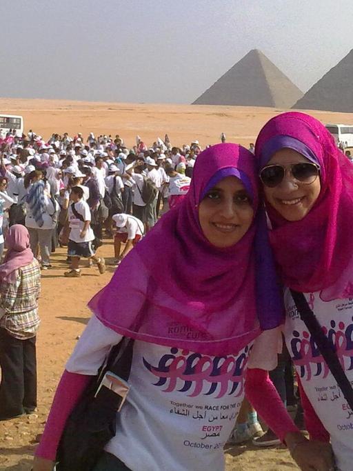 Viele ägyptische Frauen haben sich nahe der Pyramiden versammelt für ein Sportereignis. Der Pyramidenlauf soll aufklären zum Thema Brustkrebs.