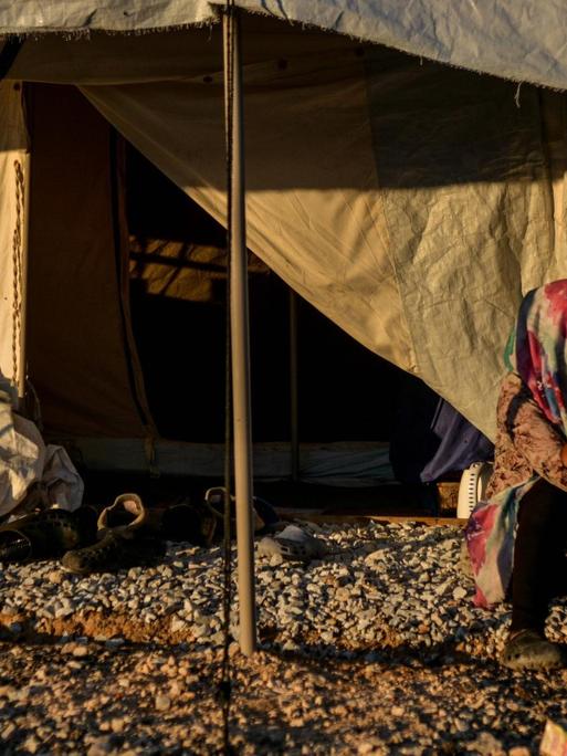 Eine Frau sitzt vor dem geöffneten Eingang eines UNHCR-Hilfszeltes im Flüchtlingscamp Kara Tepe