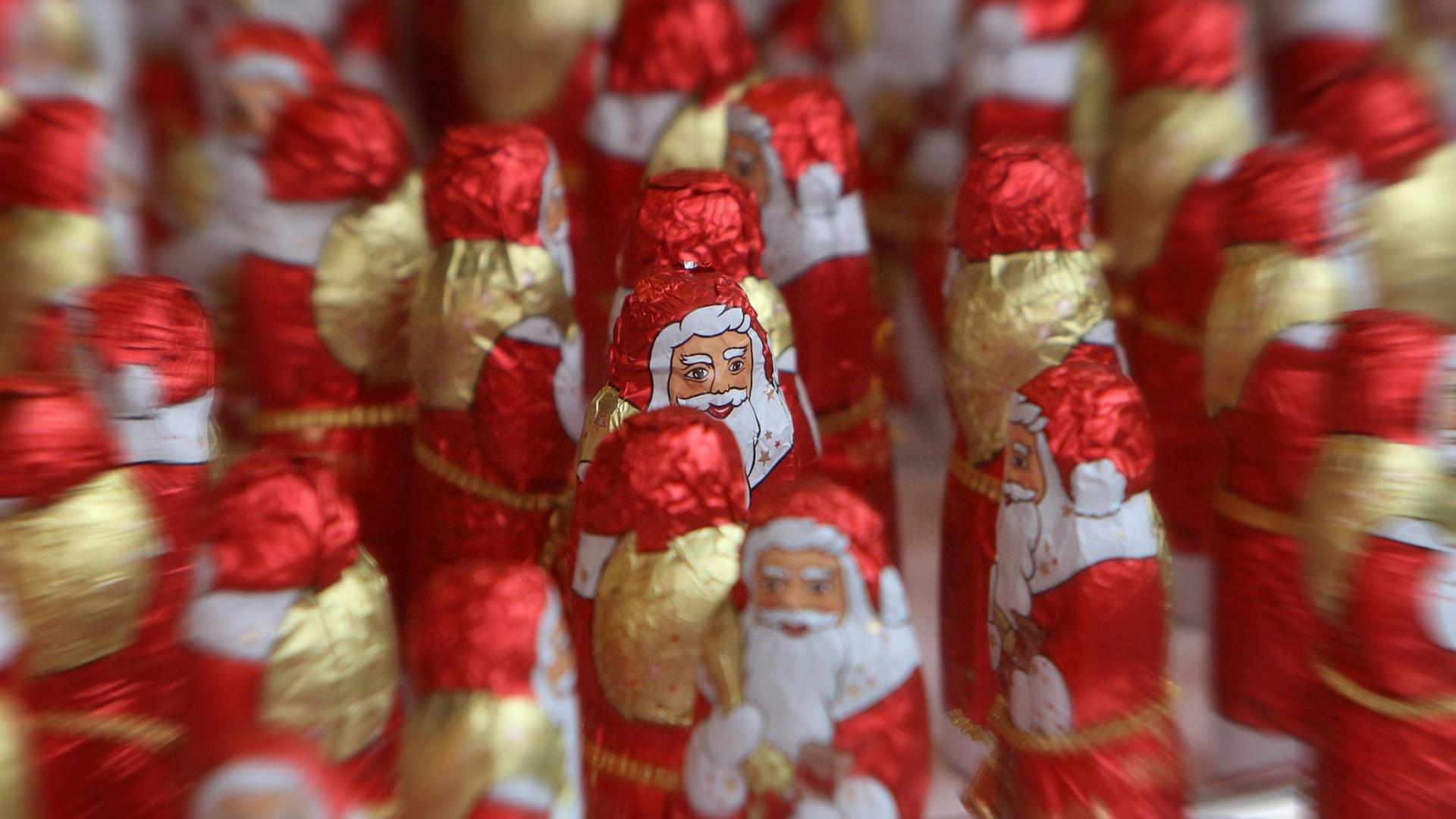 Weihnachtsmänner aus Schokolade stehen an einem Verkaufsstand auf dem Weihnachtsmarkt in Herford, Nordrhein Westfalen, Deutschland *** Santa Clauses made of chocolate stand at a sales stand at the Christmas market in Herford North Rhine-Westphalia Germany