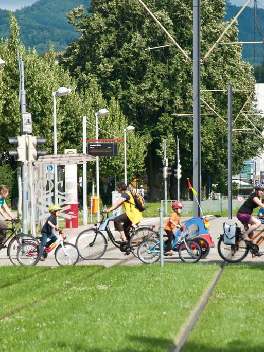 In der autofreien Siedlung Vauban queren Fahrradfahrer eine Straßenbahnlinie.