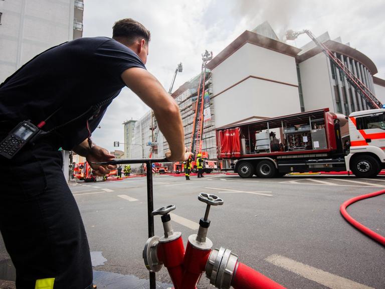 Ein Feuerwehrmann bedient vor dem Museum für Moderne Kunst einen Hydranten zu Löscharbeiten.