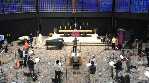 Blick von der Empore hinunter ins Kirchenschiff, wo die Sängerinnen und Sänger mit großem Abstand stehen und proben.