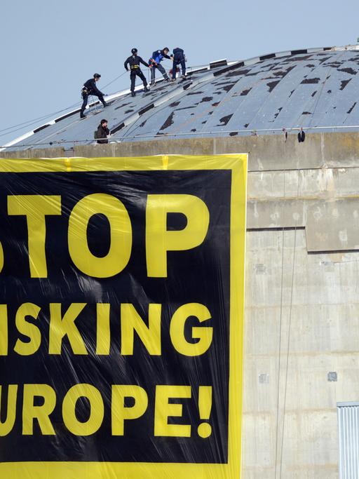 Greenpeace protestiert mit einem Plakat mit der Aufschrift "Stop Risiking Europe" auf dem Dach des französischen Atomkraftwerks Fessenheim.