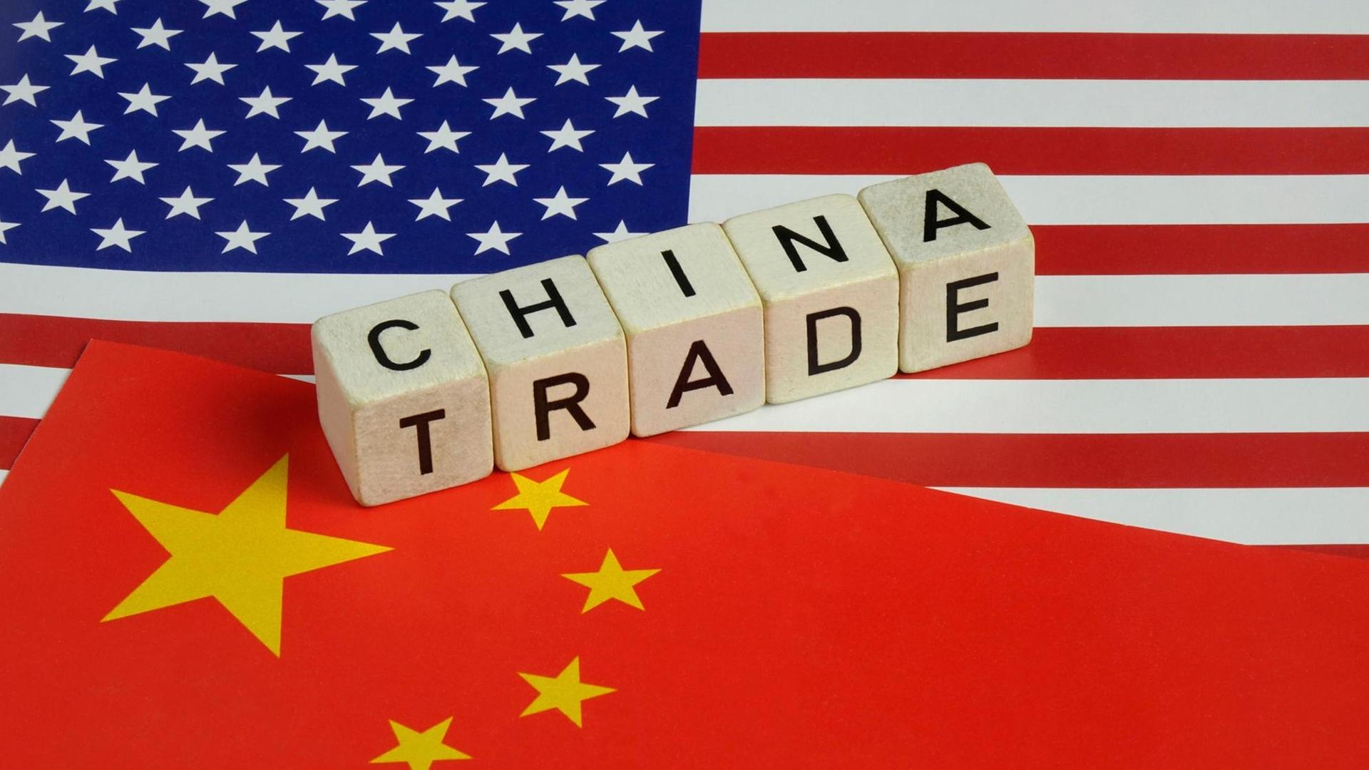 Auf einer chinesischen und amerikanischen Flagge liegen die Worte China Trade.