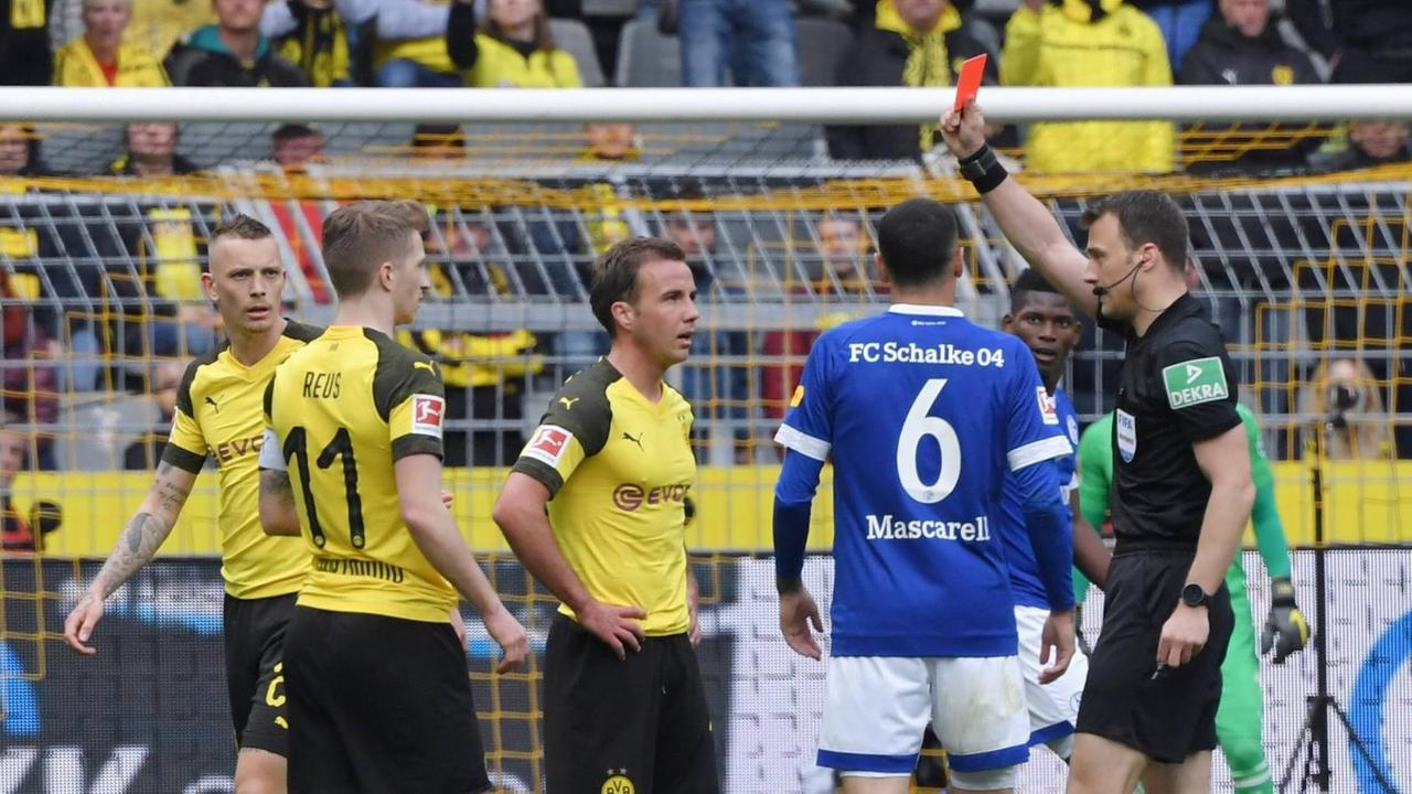 Das Foto zeigt eine Szene aus dem Spiel Borussia Dortmund gegen FC Schalke 04. Marco Reus erhält die Rote Karte von Schiedsrichter Felix Zwayer.
