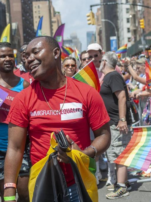 Die 49. Gay Pride Parade in New York, 2018, hier mit afroamerikanischen Teilnehmern mit Regenbogenfahnen bei der Strassenparade