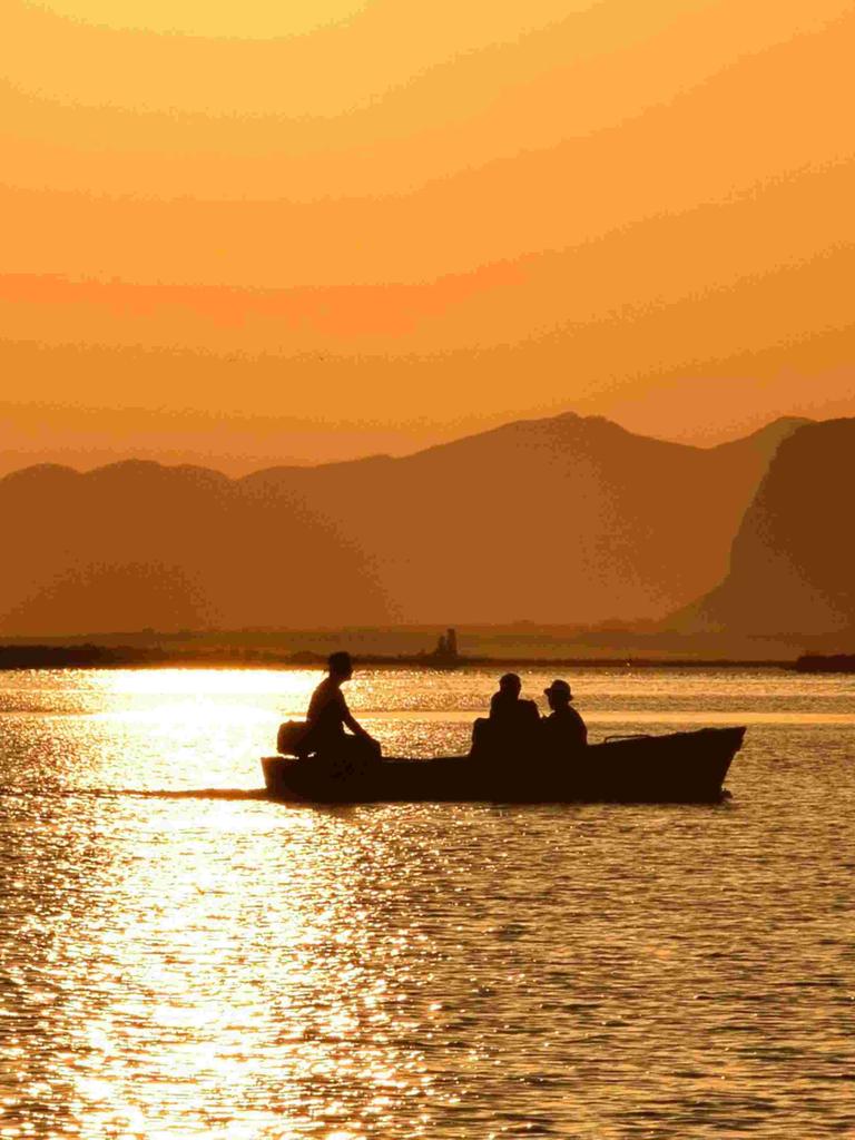 Sizialianische Küste: Silhouette eines Boots vor orangenem Sonnenuntergang. 