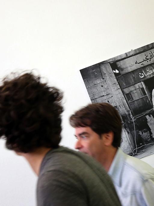 Besucher gehen am 28.07.2016 im Pergamonmuseum in Berlin an Bildern des syrischen Fotokünstlers Mohamad Al Roumi vorbei. Der Fotokünstler zeigt in einer Ausstellung abseits von Zerstörung, Leid und Tod die intakte nordost-syrische Provinz der 90er Jahre unter dem Motto: "Kontrast Syrien".