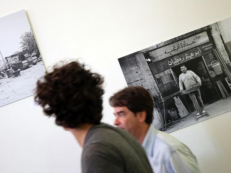 Besucher gehen am 28.07.2016 im Pergamonmuseum in Berlin an Bildern des syrischen Fotokünstlers Mohamad Al Roumi vorbei. Der Fotokünstler zeigt in einer Ausstellung abseits von Zerstörung, Leid und Tod die intakte nordost-syrische Provinz der 90er Jahre unter dem Motto: "Kontrast Syrien".
