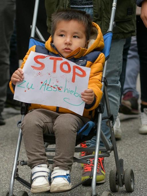 Ein Kind trägt während einer Kundgebung gegen die Abschiebung nach Afghanistan am 22.10.2016 in Hamburg in der Innenstadt ein Schild mit der Aufschrift "Stop zu Abschiebung" in der Hand. Das Land am Hindukusch stellt nach Meinung der Protestler kein sicheres Herkunftsland dar.
