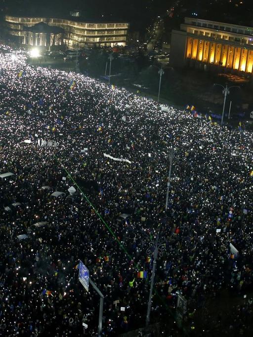 Das Bild zeigt Hunderttausende Menschen, die am Abend des 05.02.2017 vor dem Parlamentspalast in der rumänischen Hauptstadt Bukarest gegen die sozialliberale Regierung demonstrieren. Es ist bereits dunkel, aber die von obenen gesehenen Massen sind angeleuchtet.