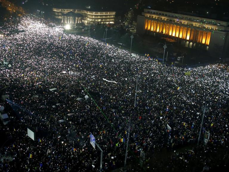 Das Bild zeigt Hunderttausende Menschen, die am Abend des 05.02.2017 vor dem Parlamentspalast in der rumänischen Hauptstadt Bukarest gegen die sozialliberale Regierung demonstrieren. Es ist bereits dunkel, aber die von obenen gesehenen Massen sind angeleuchtet.