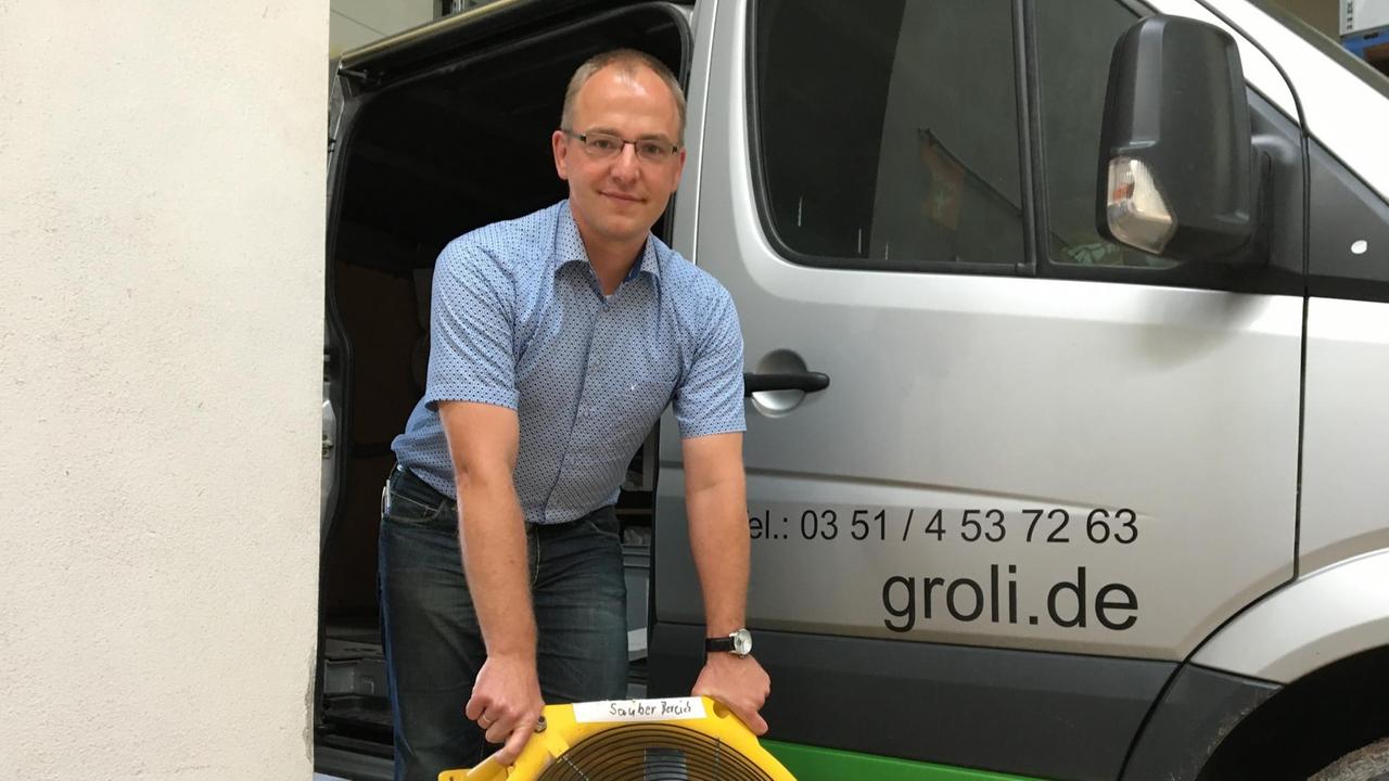 Marco Müller, Geschäftsführer der Groli Schädlingsbekämpfung vor einem Firmenfahrzeug (Bild: Deutschlandradio / Bastian Brandau)