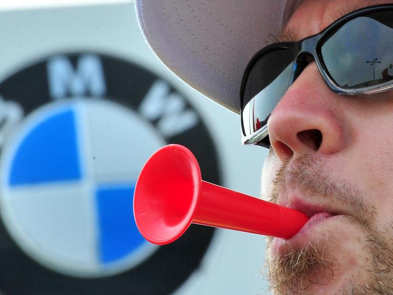 Beim Warnstreik im Leipziger BMW-Werk 2012 bläst ein IG-Metaller in seine Tröte.