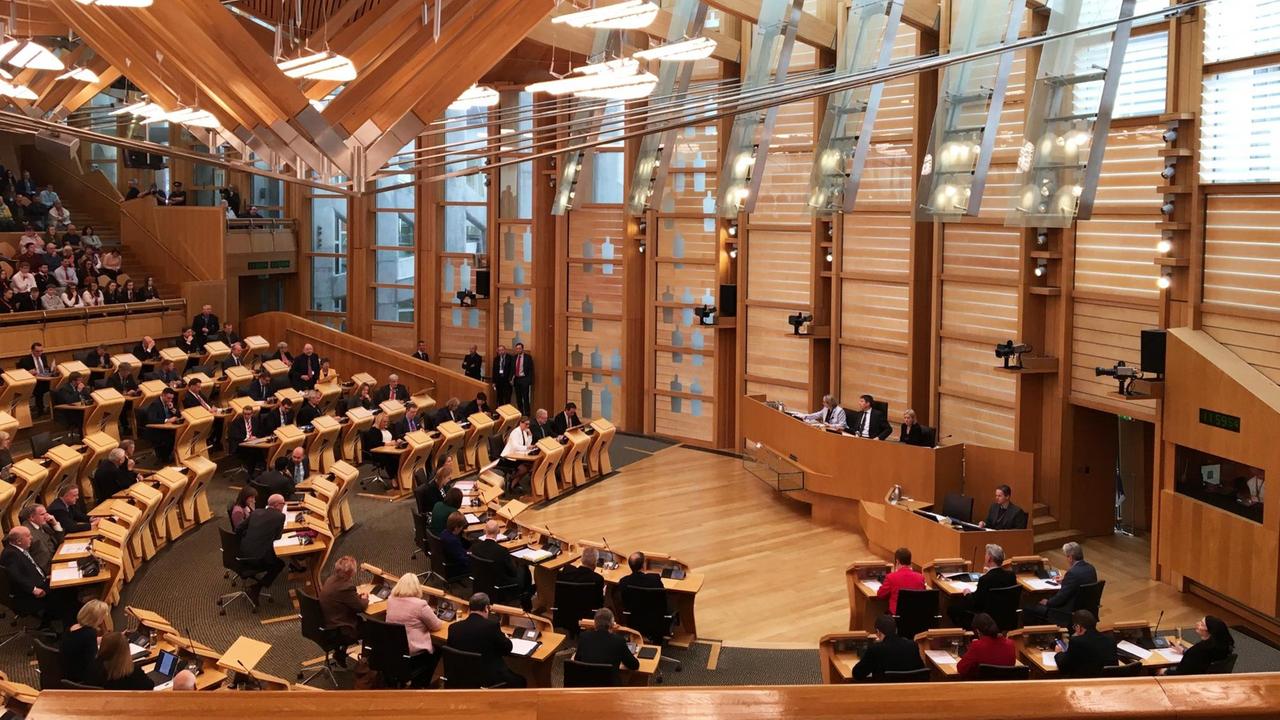 Blick in das schottische Parlament in Edinburgh. Regierungsbank und Plätze der Abgeordneten sind zu sehen.