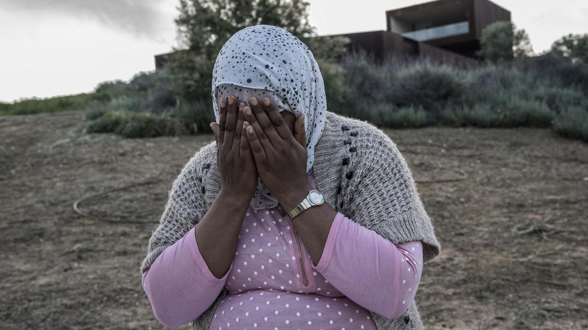 Kalima aus Marokko hält sich beide Hände vor das Gesicht