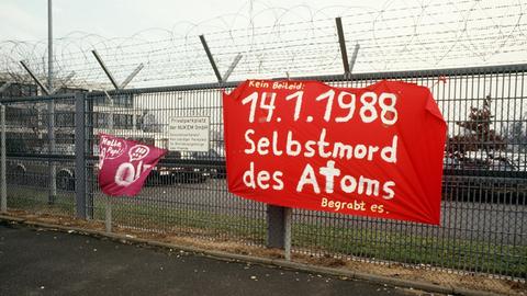 Atomkraft-Gegner haben am 14.1.1988 an dem mit Stacheldraht gesicherten Sperrzaun auf dem Gelände der Hanauer Atomfabrik Nukem ein Plakat angebracht. Die Firma wurde wegen unerlaubter Transport von spaltbarem Material und dem Verdacht illegaler Auslandslieferungen geschlossen.