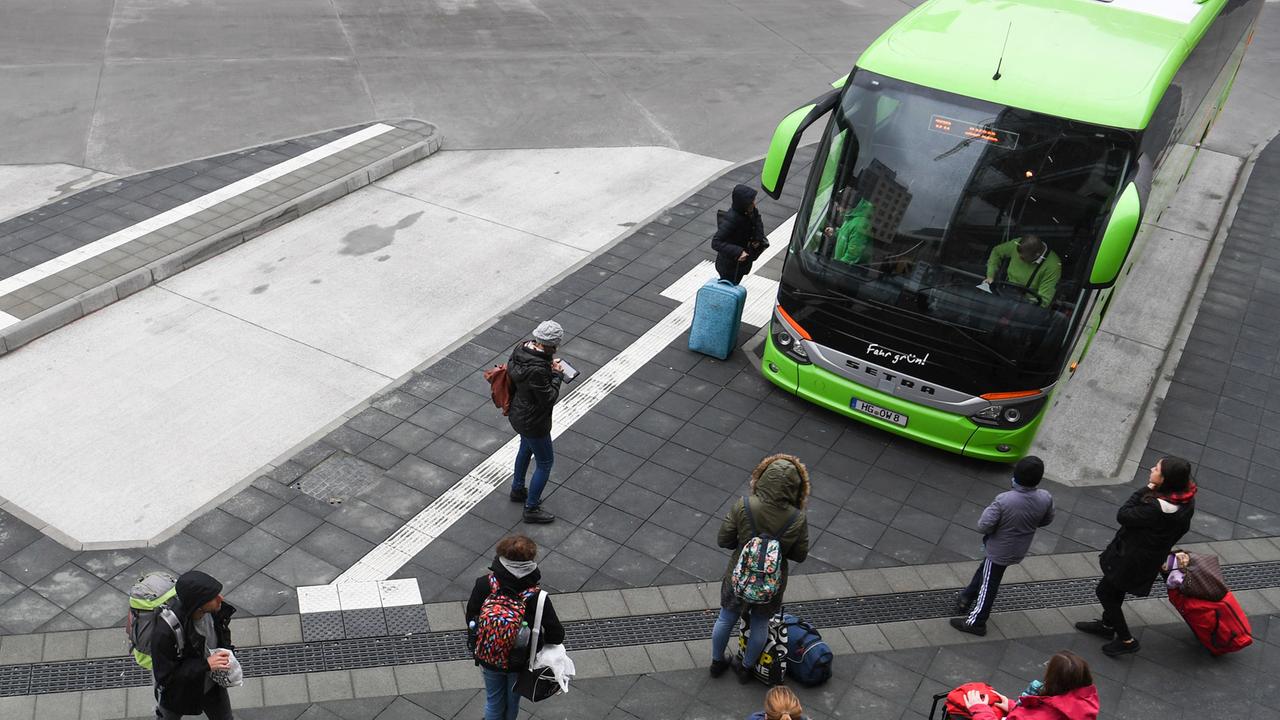 Reisende warten an einer Haltestelle am Hauptbahnhof von Frankfurt am Main vor einem Reisebus des Unternehmens "MeinFernbus FlixBus". 