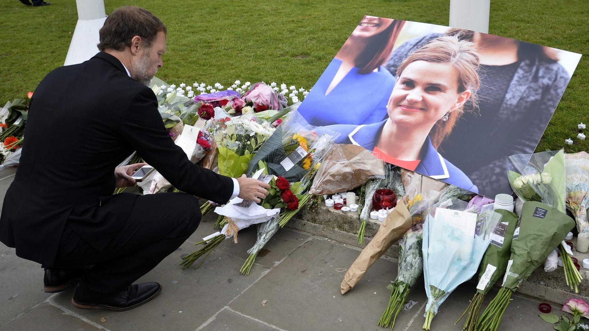 Ein Mann legt Blumen ab zum Gedenken an die ermordete Abgeordnete Jo Cox auf dem Parliament Square in London