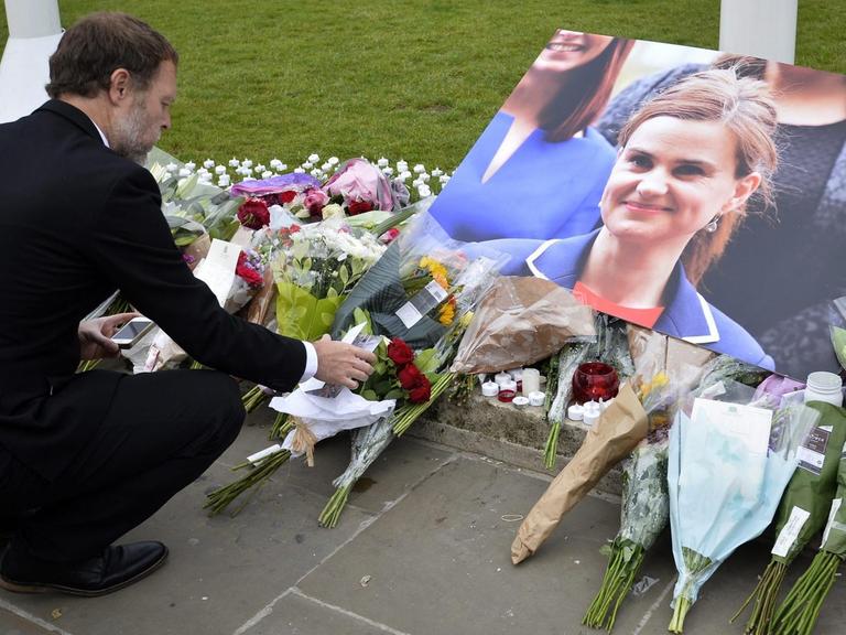 Ein Mann legt Blumen ab zum Gedenken an die ermordete Abgeordnete Jo Cox auf dem Parliament Square in London