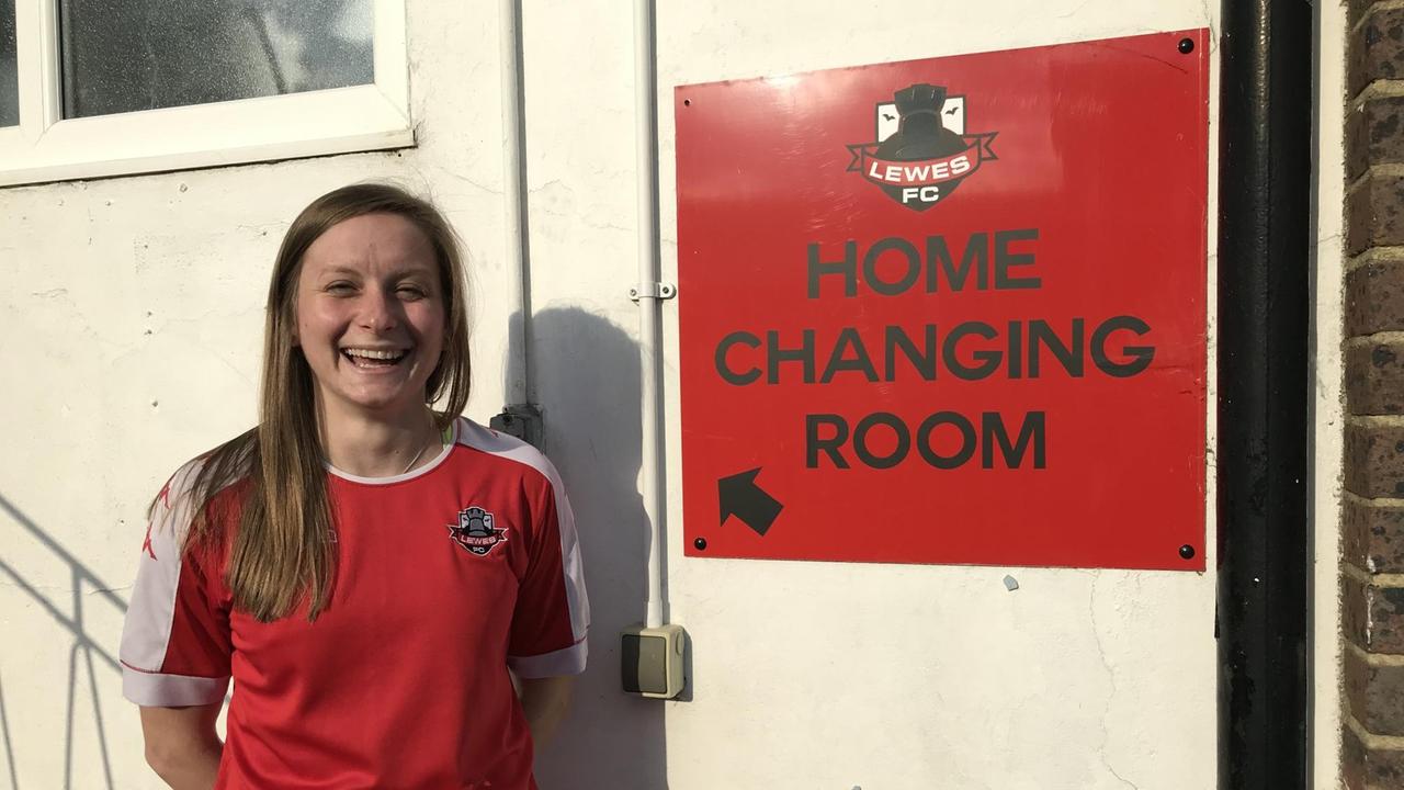 Die Spielerin Amy Taylor steht vor der Umkleidekabine des Lewes FC.