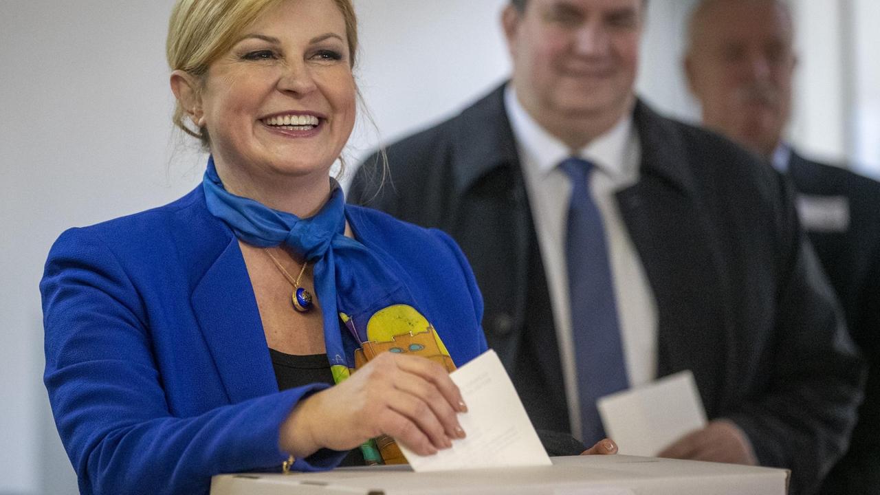 Das Bild zeigt die kroatische Präsidentin Grabar Kitarovic, wie sie lächelnd in einem Wahllokal ihre Stimme abgibt. 