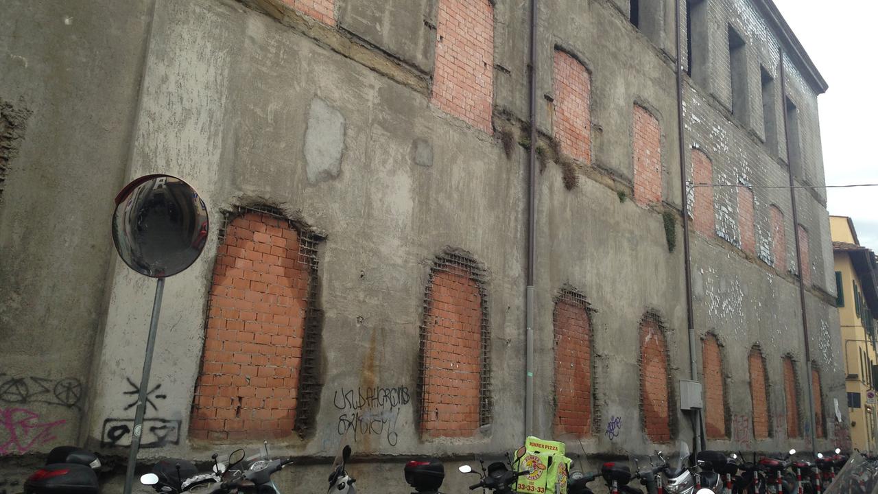 Das Kloster Sant'Orsola von außen: Eine graue Wand, die Fenster mit Backsteinen zugemauert