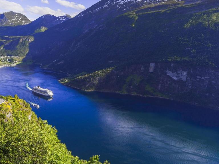 Ein Kreuzfahrtschiff verlässt die Bucht von Geiranger. Norwegen ist ein beliebtes Ziel für Kreuzfahrtkunden. Dort darf aber ab 2026 kein Schiff mehr mit Verbrennungsmotor in die Fjorde einfahren.