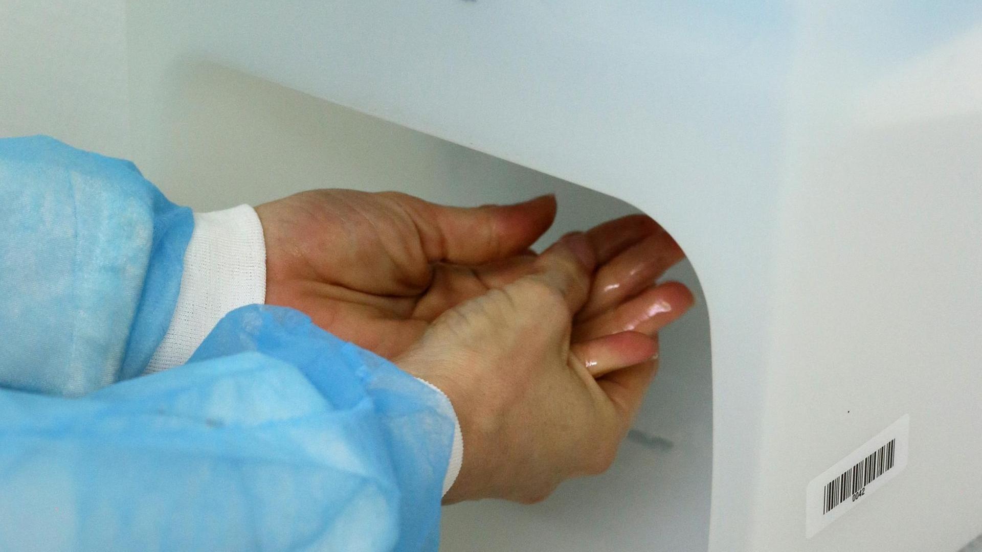 Ein Arzt desinfiziert sich seine Hände im Krankenhaus