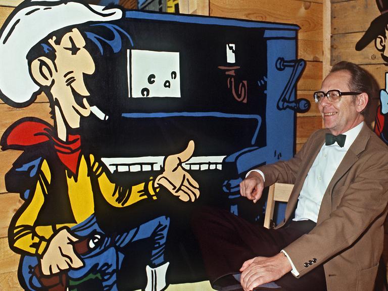 Das Foto zeigt den Zeichner Maurice de Bévère, besser bekannt als Morris, im Jahr 1985 mit seiner Comicfigur Lucky Luke auf einer Ausstellung im château de la Chapelle d'Angillon.