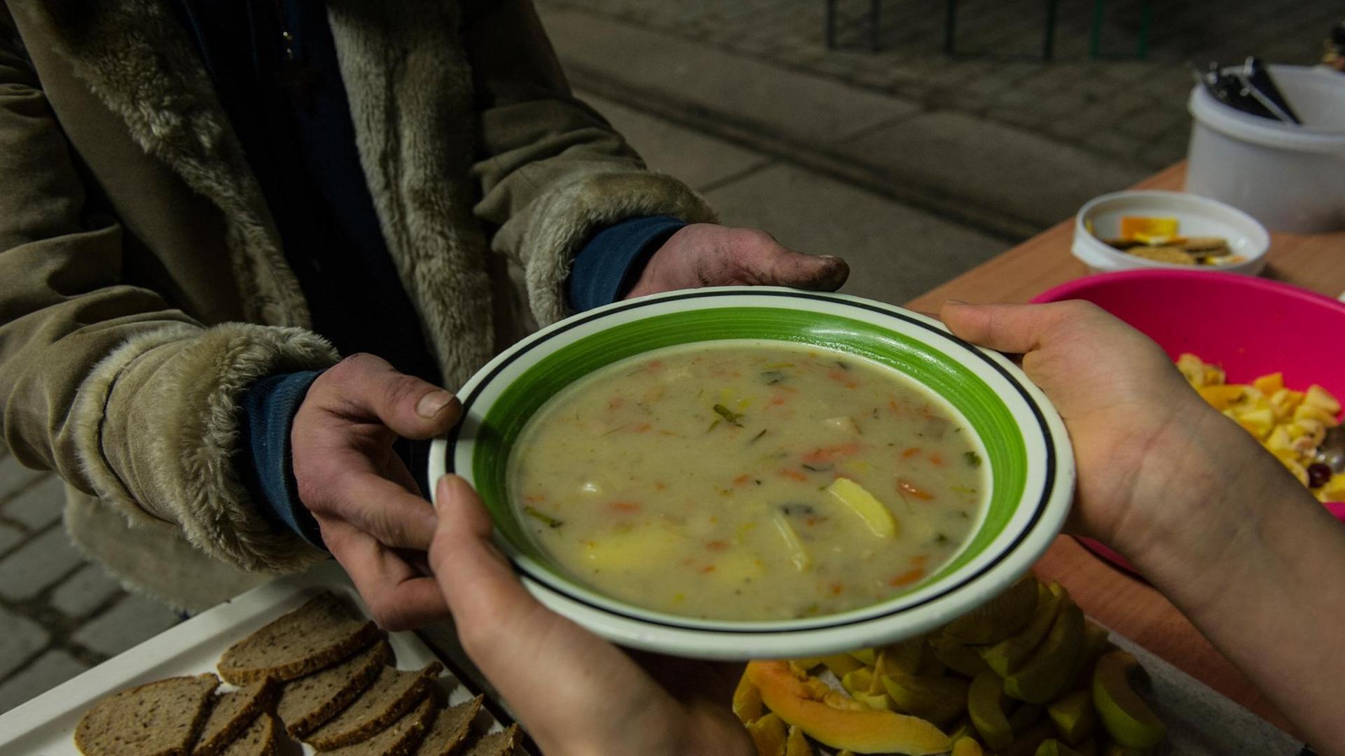 Ein Obdachloser bekommt am 19.02.2014 in Berlin eine Suppe in einer Wärmelufthalle. Die Berliner Stadtmission hat das provisorisch errichtete Gebäude als Nachtquartier für Obdachlose unweit des Innsbrucker Platzes vorgesehen.