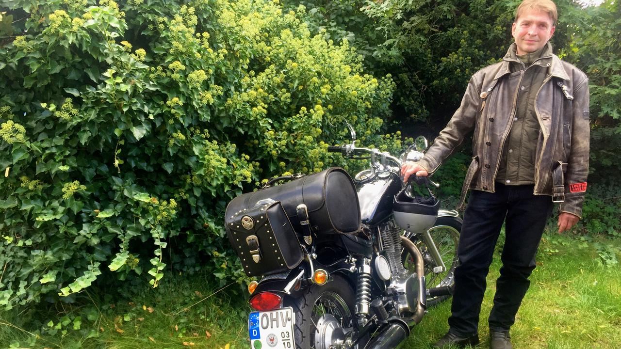 Christian von der Gruppe "Christ und Motorrad" des Bikerpfarrers Bernd Schade steht neben seiner Maschine.