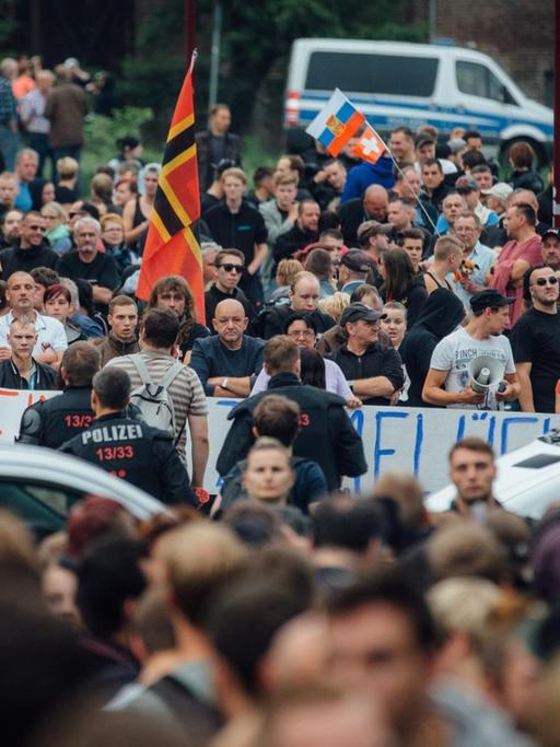 Gegner der Flüchtlingsunterkunft stehen am 26.06.2015 in Freital (Sachsen) in der Nähe des ehemaligen Leonardo-Hotels, das jetzt als Flüchtlingsheim dient.