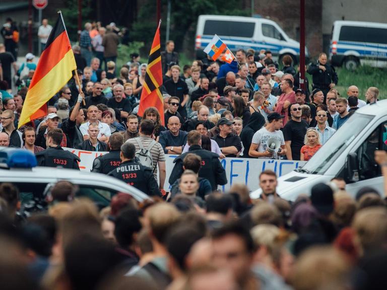 Gegner der Flüchtlingsunterkunft stehen am 26.06.2015 in Freital (Sachsen) in der Nähe des ehemaligen Leonardo-Hotels, das jetzt als Flüchtlingsheim dient.