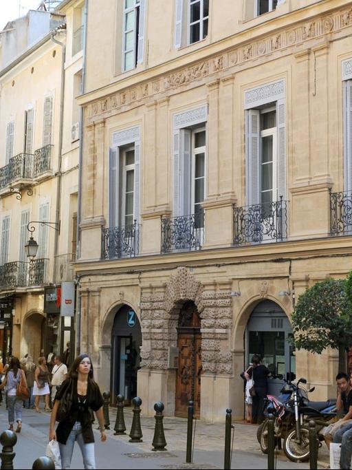 Touristen laufen durch eine Gasse in der Altstadt von Aix-en-Provence