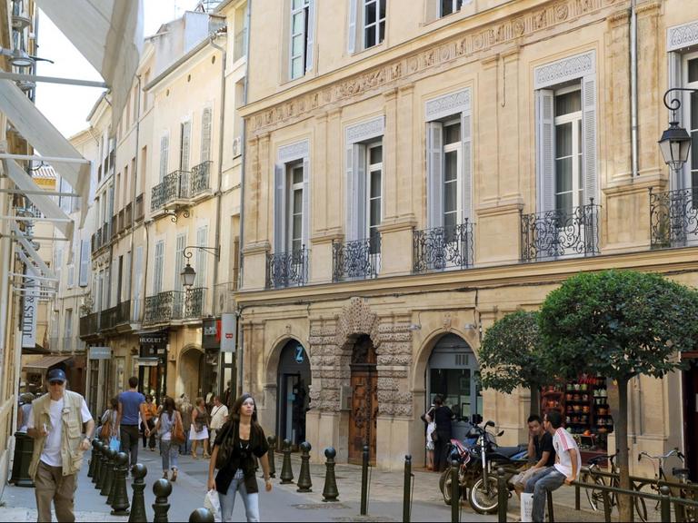 Touristen laufen durch eine Gasse in der Altstadt von Aix-en-Provence