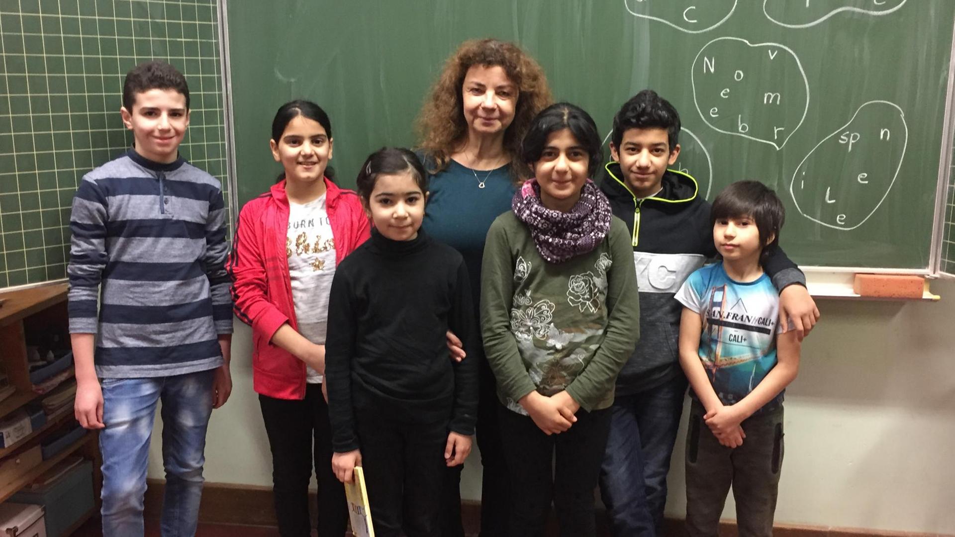 Schülerinnen und Schüler der Willkommensklasse mit der Lehrerin Tatjana Köster in der Charles-Dickens-Schule