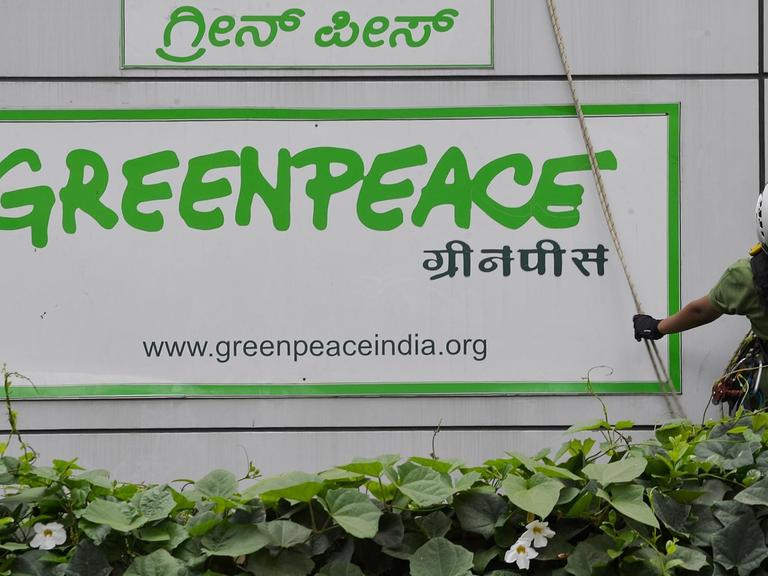 Greenpeace Aktivisten befestigen am 15. Mai 2015 große Banner an die Außenfassade des Hauptquartiers im indischen Bagalore, um gegen die Einschränkungen durch die Regierung Indiens zu demonstrieren.