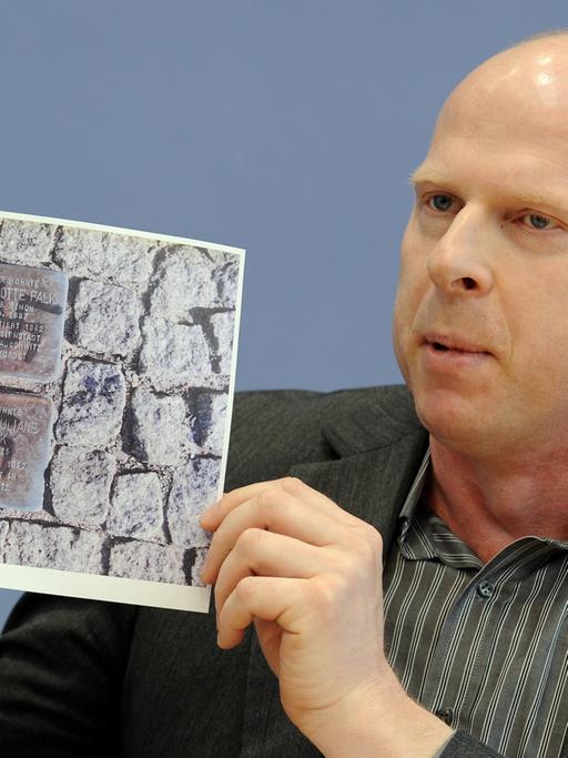 Jörg Wanke von der Bürgerinitiative "Zossen zeigt Gesicht" zeigt rechtsextreme Schmierereien aus seiner Gemeinde in Brandenburg (Archivbild vom 8. März 2010).