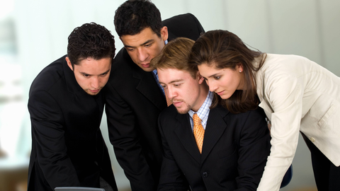 Ein Mann und eine Frau in Business-Look beugen sich gemeinsam über einen Laptop-Computer